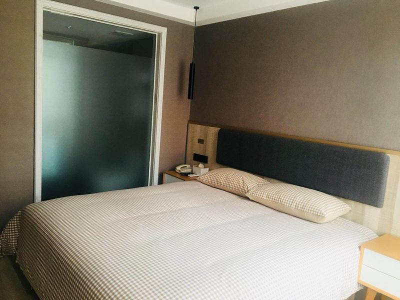 a bedroom with a bed with two pillows on it at Up And In Guangdong Heyuan Dongcheng West Area Taohuashuimu in Heyuan