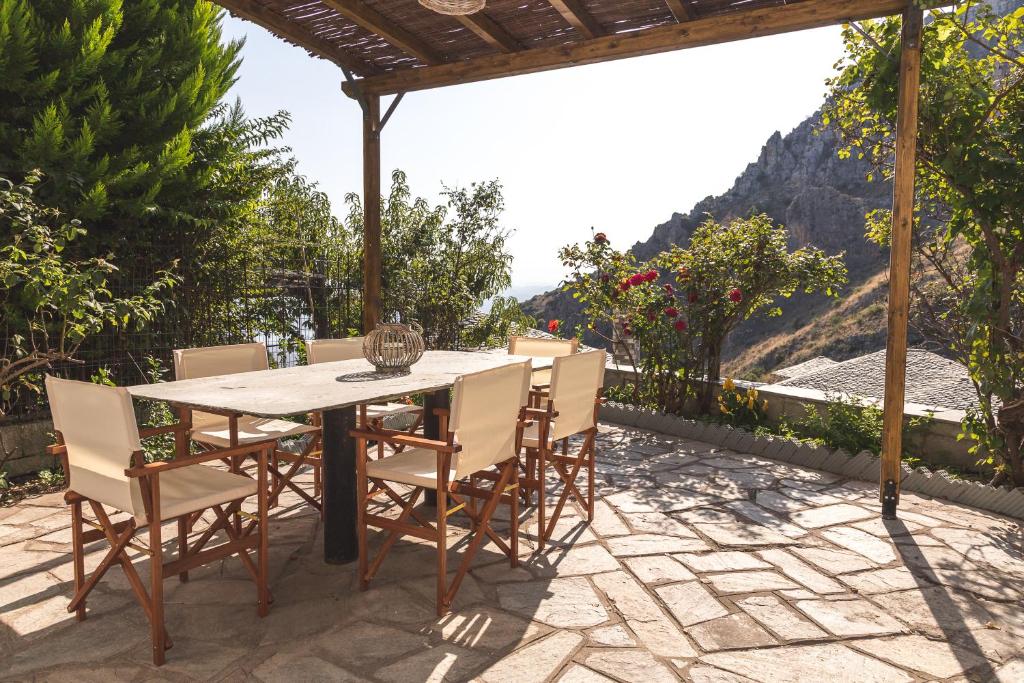- une table et des chaises sur une terrasse avec vue dans l'établissement Villa Ntona, à Makrinitsa