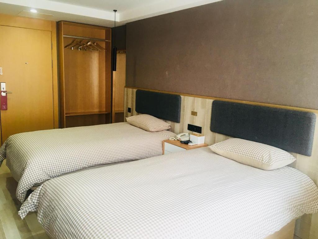 two beds sitting next to each other in a room at Up And In Guangdong Heyuan Dongcheng West Area Taohuashuimu in Heyuan