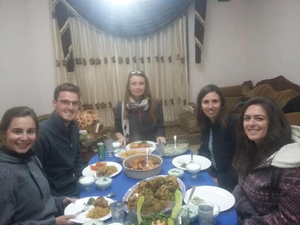 a group of people sitting around a table with food at Moon house in Wadi Musa