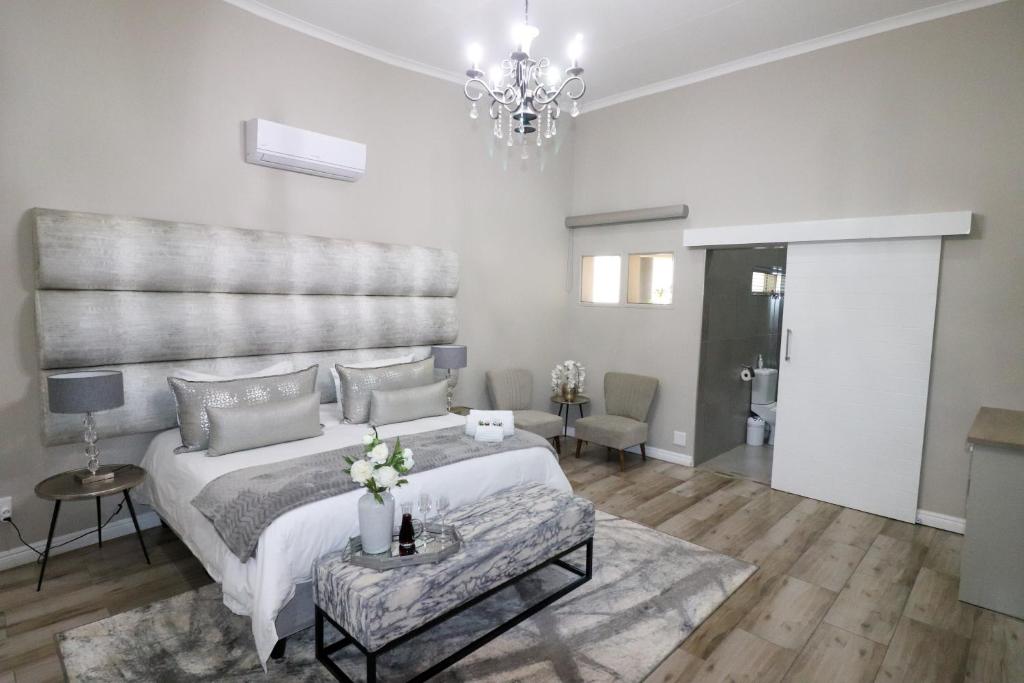 a bedroom with a large bed and a chandelier at Stonehill Villa in Bloemfontein