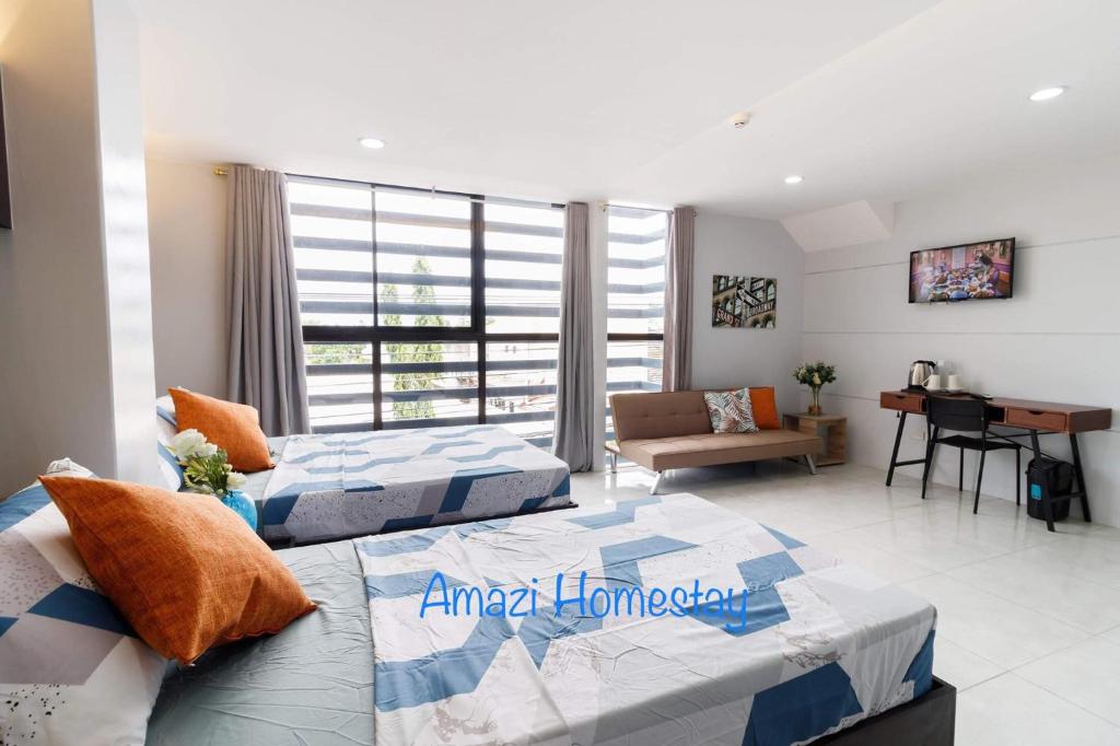 a bedroom with two beds and a living room at Amazi Homestay-Dumaguete in Dumaguete