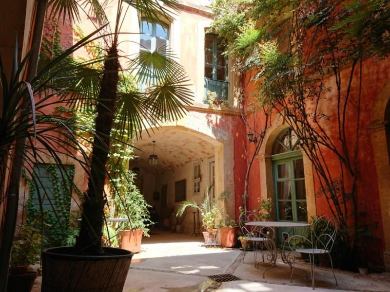 a courtyard with a table and chairs in a building at Rue du Château in Tarascon