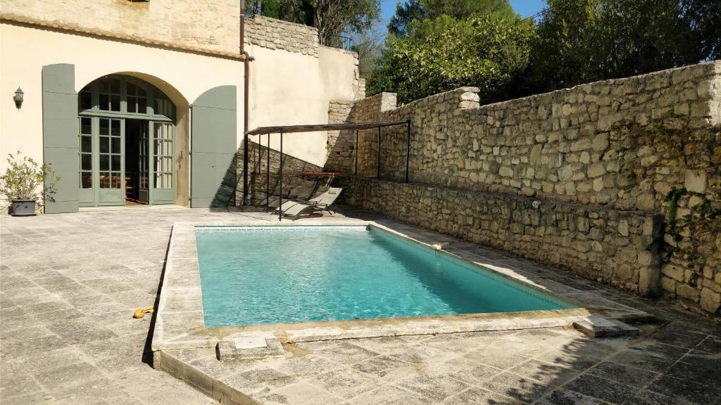 una piscina frente a una pared de piedra en Appartement avec Piscine privée dans Résidence pour 6 personnes, en Uzès