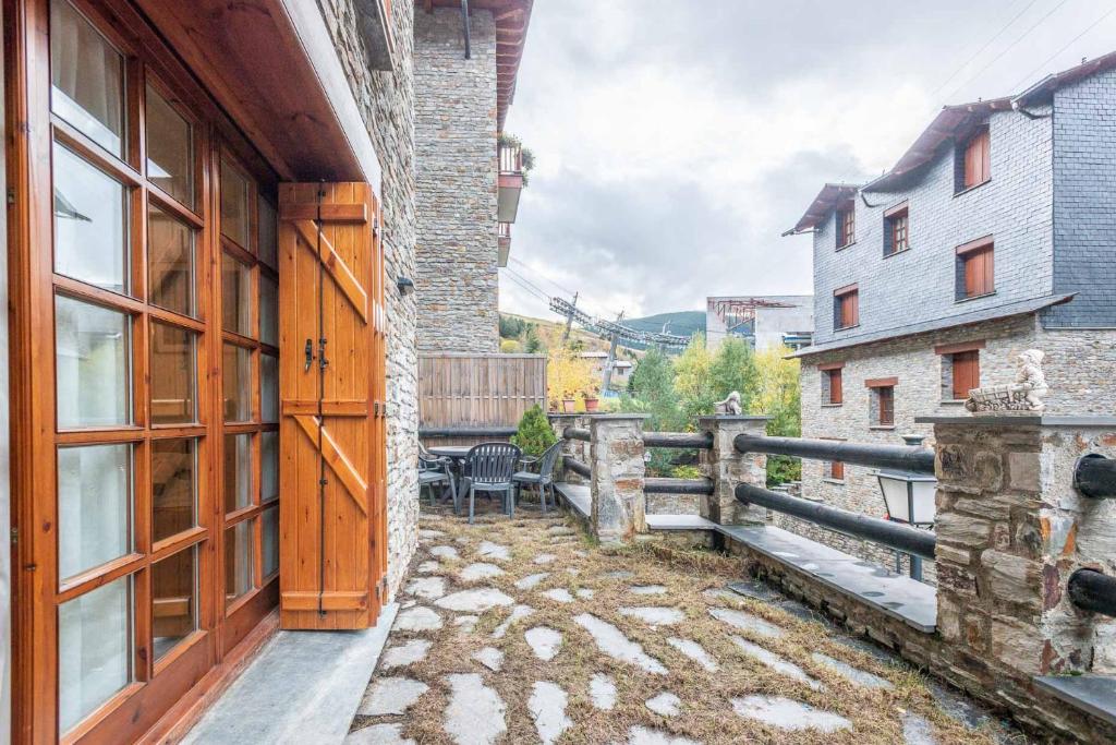 a building with a wooden door and a fence at Apartamento Refugi in Canillo