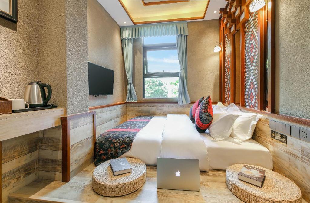 een slaapkamer met een bed met een laptop erop bij Zou Qu Ye Travel Hotel in Chongqing