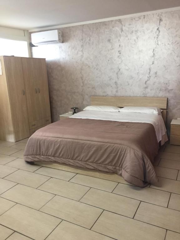 ナポリにあるA casa e Luciaのタイルフロアのベッドルーム1室(大型ベッド1台付)