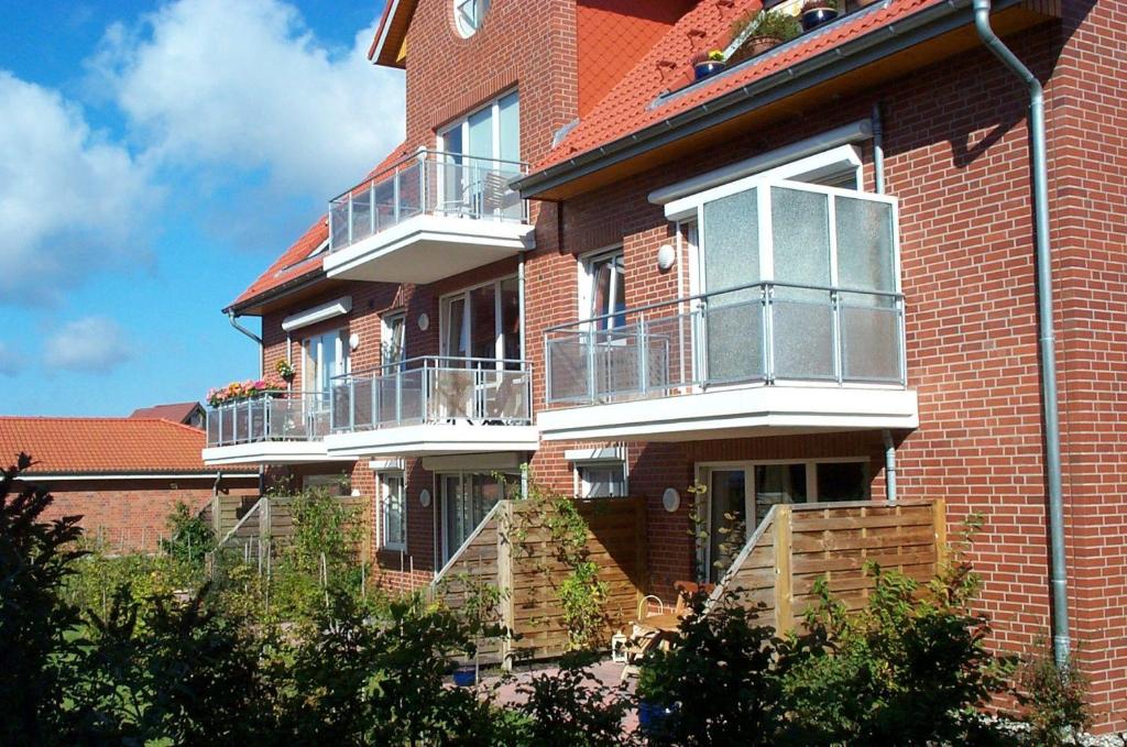 Un edificio de ladrillo con balcones y escaleras. en BUPA02208-Ferienwohnung-Passat, en Burg auf Fehmarn
