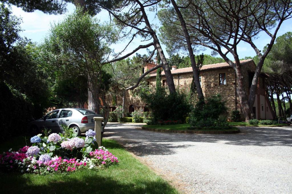 a car parked in front of a house with flowers at Villa Bolgherello in Marina di Bibbona
