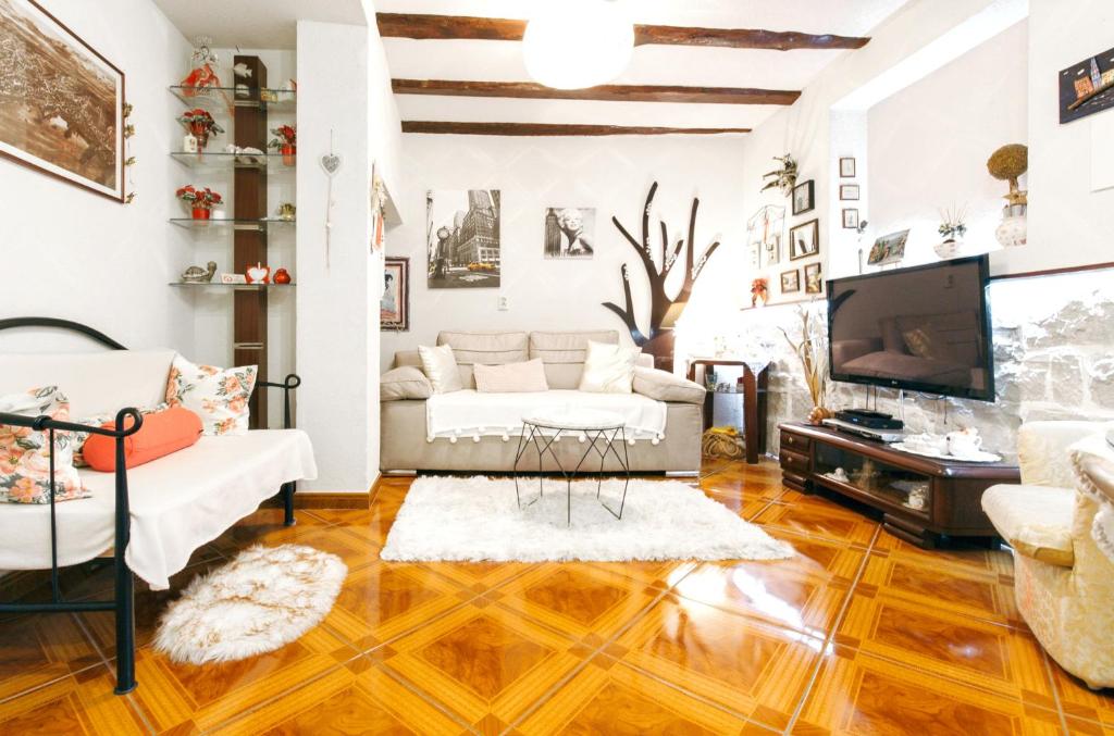 a living room with white furniture and a flat screen tv at One bedroom appartement at Split 500 m away from the beach with enclosed garden and wifi in Split