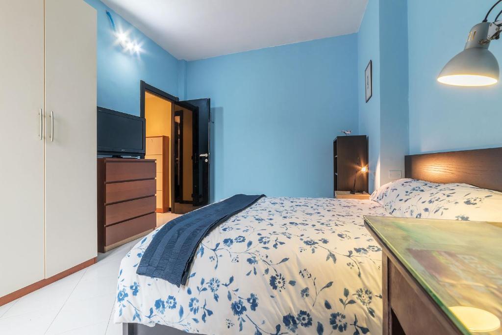 una camera blu con un letto e una televisione di Pigneto Colourful Apartment a Roma