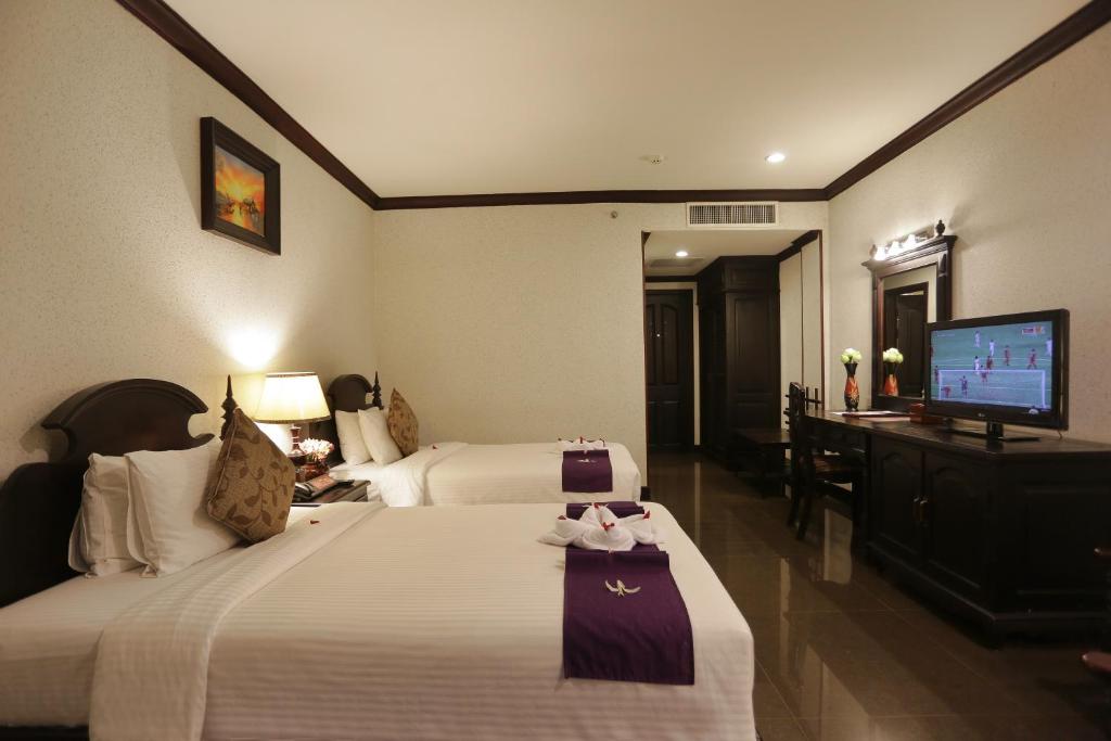 Postel nebo postele na pokoji v ubytování Lucky Angkor Hotel & Spa