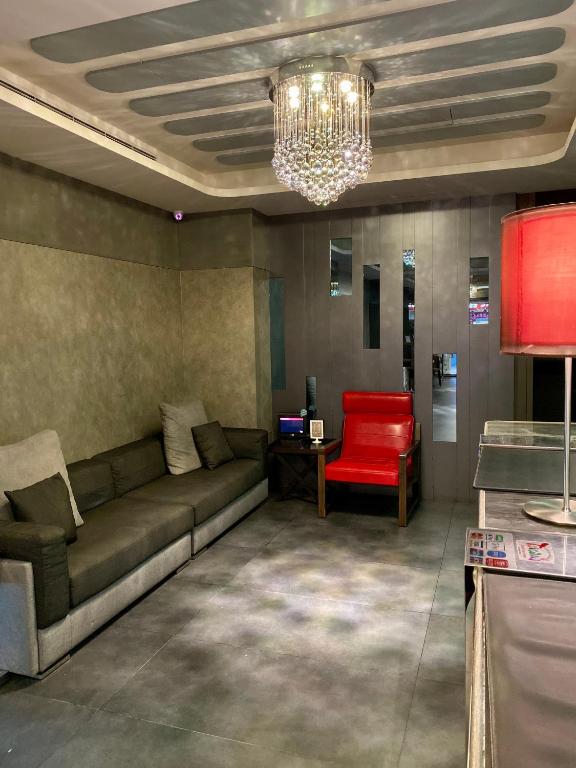 a living room with a couch and a red chair at Beauty Hotels Taipei - Hotel B7 in Taipei