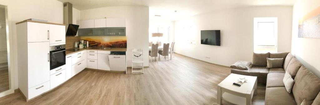 a large living room with a couch and a kitchen at Zur Strandwiese W1 in Dahme