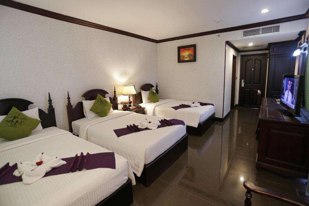 Postel nebo postele na pokoji v ubytování Lucky Angkor Hotel & Spa