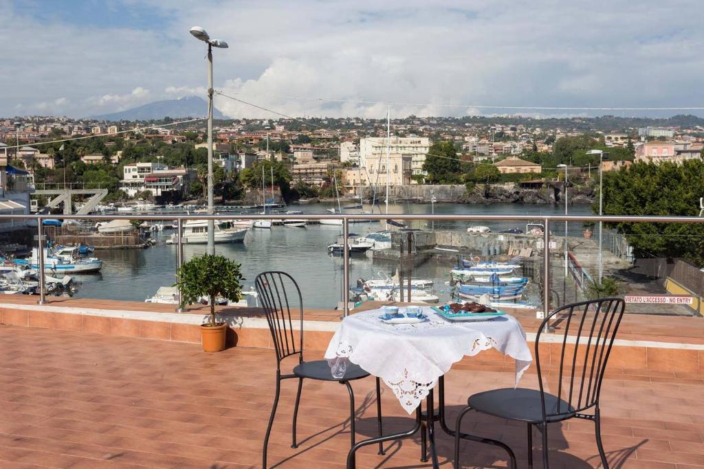 un tavolo e sedie su un balcone con porto turistico di La casa di Nonna Maria a Catania