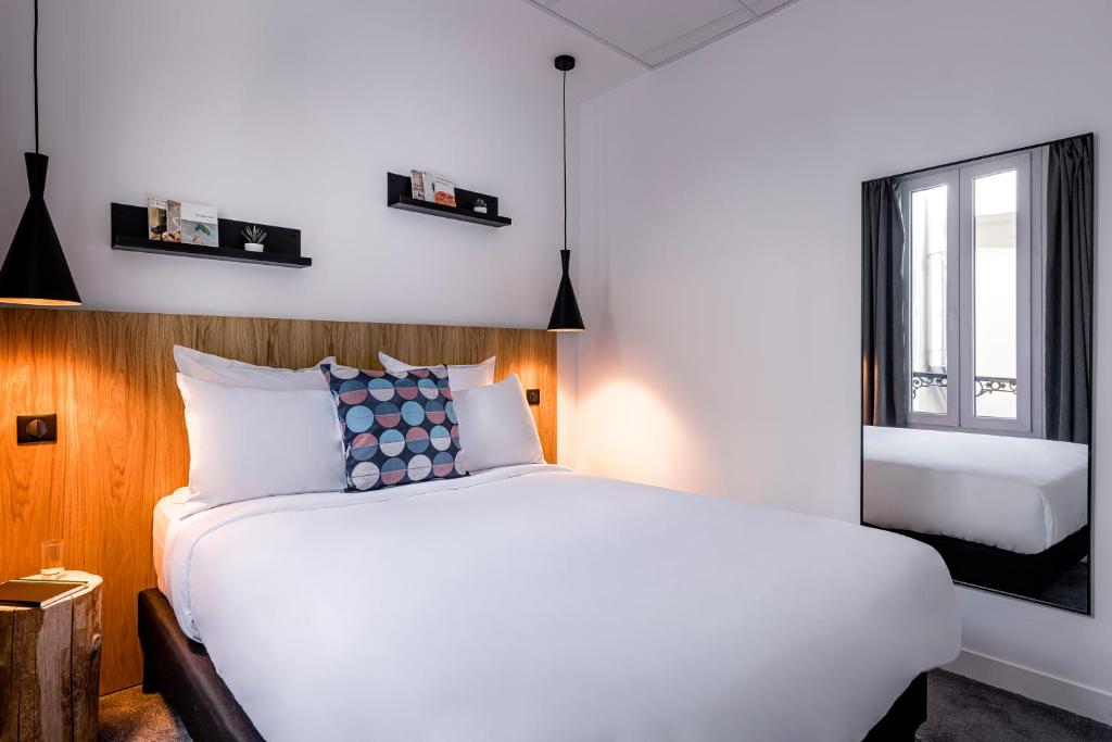 a bedroom with a white bed and a window at 9Hotel Bastille-Lyon in Paris