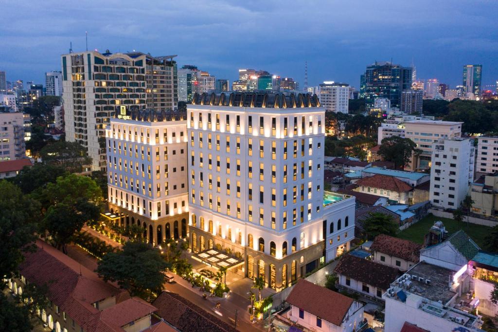 a large white building in a city at night at Mai House Saigon Hotel in Ho Chi Minh City