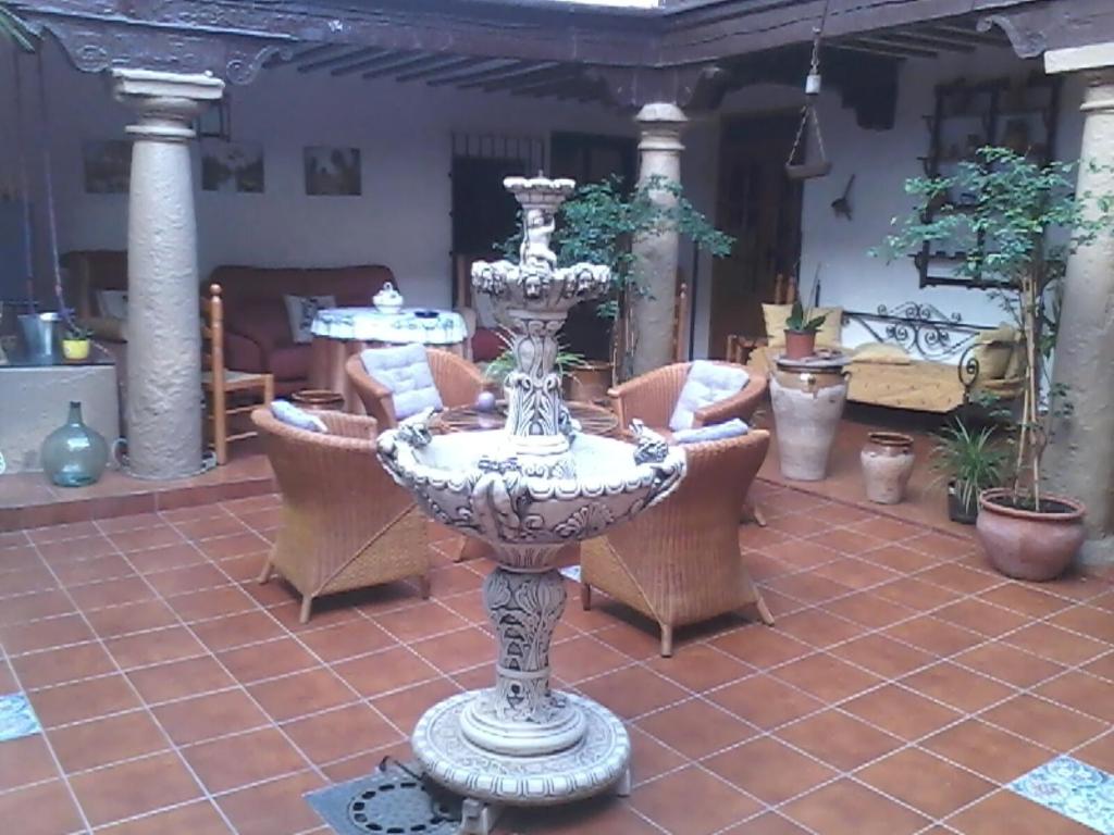 un grand vase assis sur une terrasse avec des chaises dans l'établissement Los Girones Pacheco, à Villanueva de los Infantes