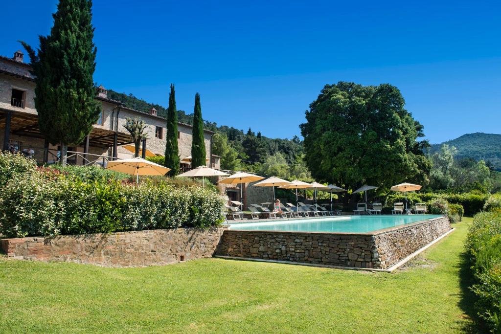 una piscina en un patio con sombrillas en Il Defizio, en Gambassi Terme