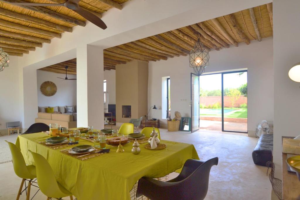 a dining room with a yellow table and chairs at La Villa douce in Marrakesh