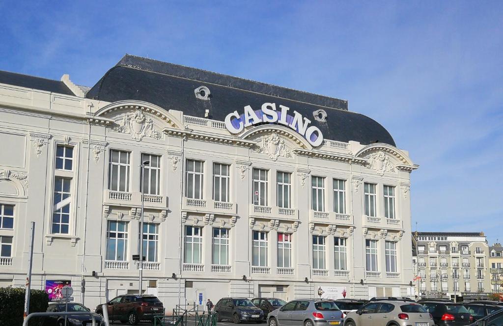 a large white building with a sign on it at Study du pêcheur in Trouville-sur-Mer
