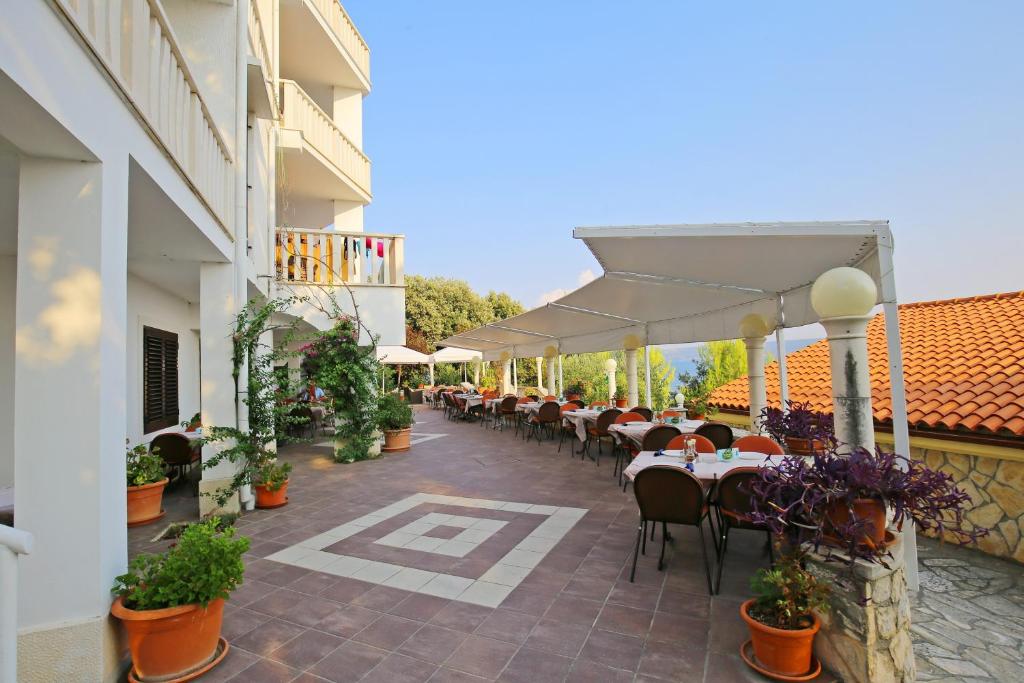 patio ze stołami i krzesłami w budynku w obiekcie Depadansa Hotel Lucija*** w mieście Posedarje
