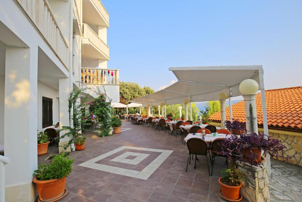 a patio with tables and chairs on a building at Depadansa Hotel Lucija*** in Posedarje