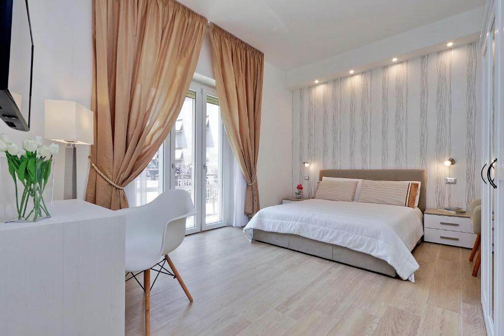 Un dormitorio blanco con una cama blanca y una ventana en My Little Holiday, en Roma