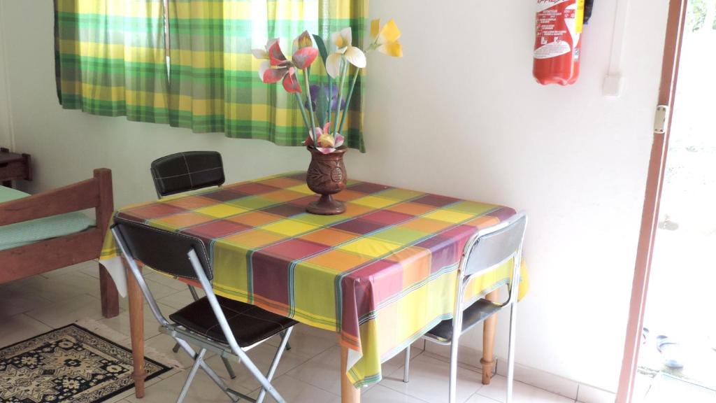 einen Tisch mit einer Blumenvase drauf in der Unterkunft Appartement d'une chambre avec wifi a Le Robert a 2 km de la plage in Le Robert
