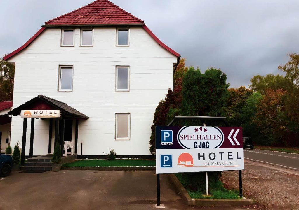 Uma casa branca com um cartaz à frente. em Hotel Geismar em Göttingen