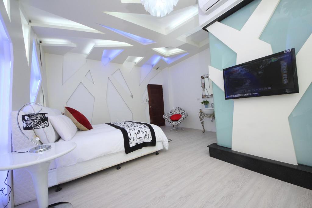 a bedroom with a bed and a flat screen tv at Chi Heng Homestay in Luodong