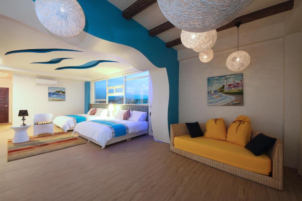 a bedroom with two beds and a couch at Chi Heng Homestay in Luodong