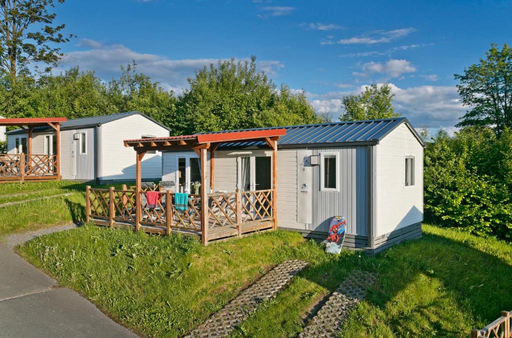 a tiny house with a deck in a yard at KNAUS Campingpark Hennesee in Meschede