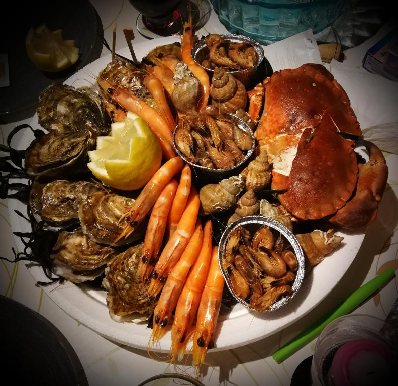 a plate of seafood and vegetables on a table at Study du pêcheur in Trouville-sur-Mer