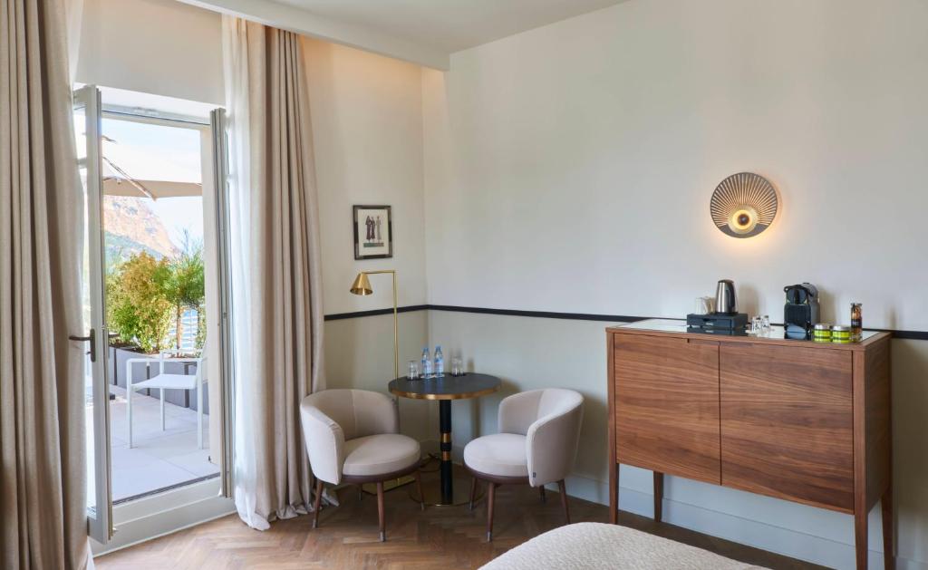 a room with a table and chairs and a window at Hôtel Les Roches Blanches Cassis in Cassis