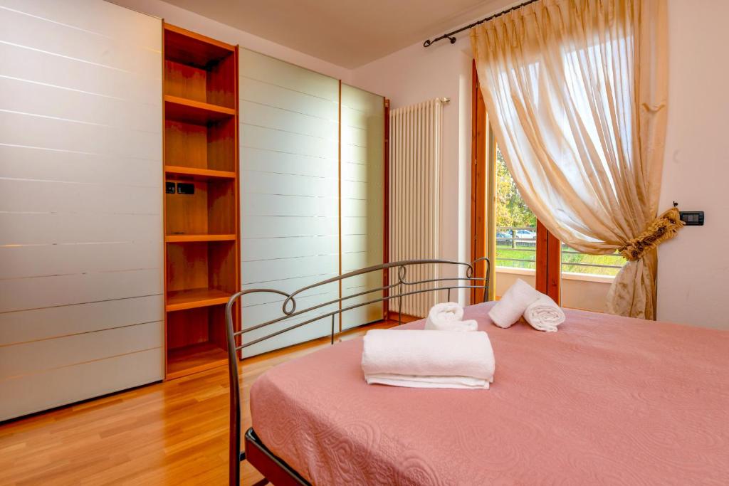 una camera da letto con un letto e asciugamani di My Peschiera Family Home XL a Peschiera del Garda