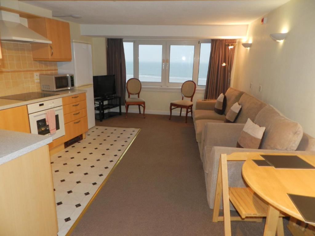 una cucina e un soggiorno con divano e tavolo di Beau Rivage a St Brelade