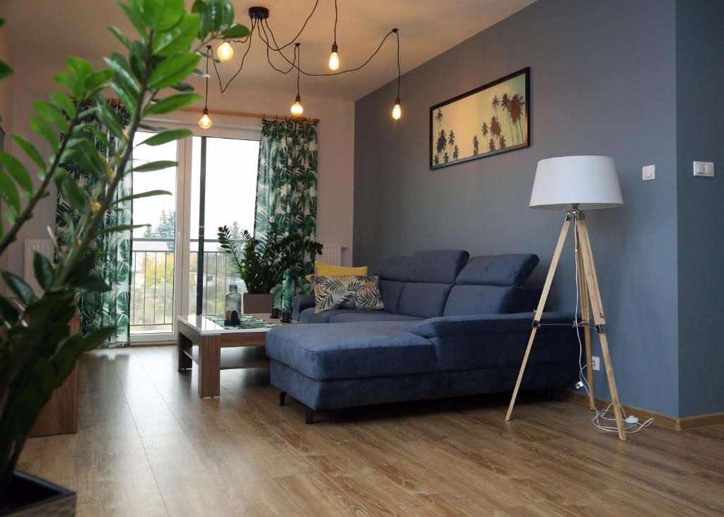sala de estar con sofá azul y lámpara en Lifestyle Apartments -Zielony Uniejow "prywatne kapiele termalne" en Uniejow
