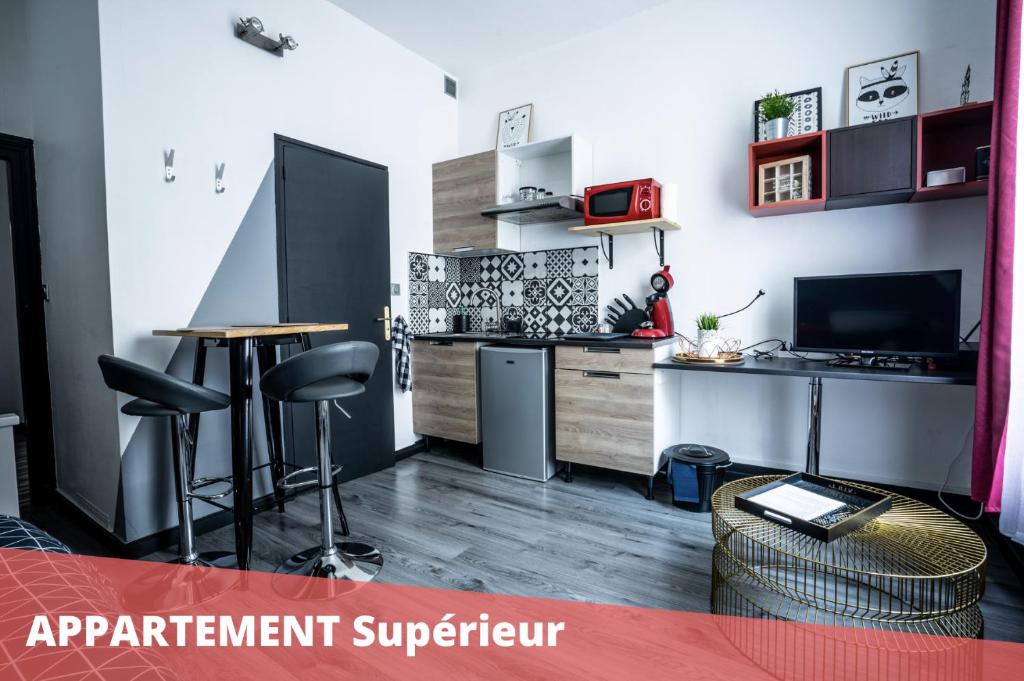 Cet appartement comprend une cuisine avec une table et un comptoir. dans l'établissement Les Apparts de Blossac Poitiers, à Poitiers