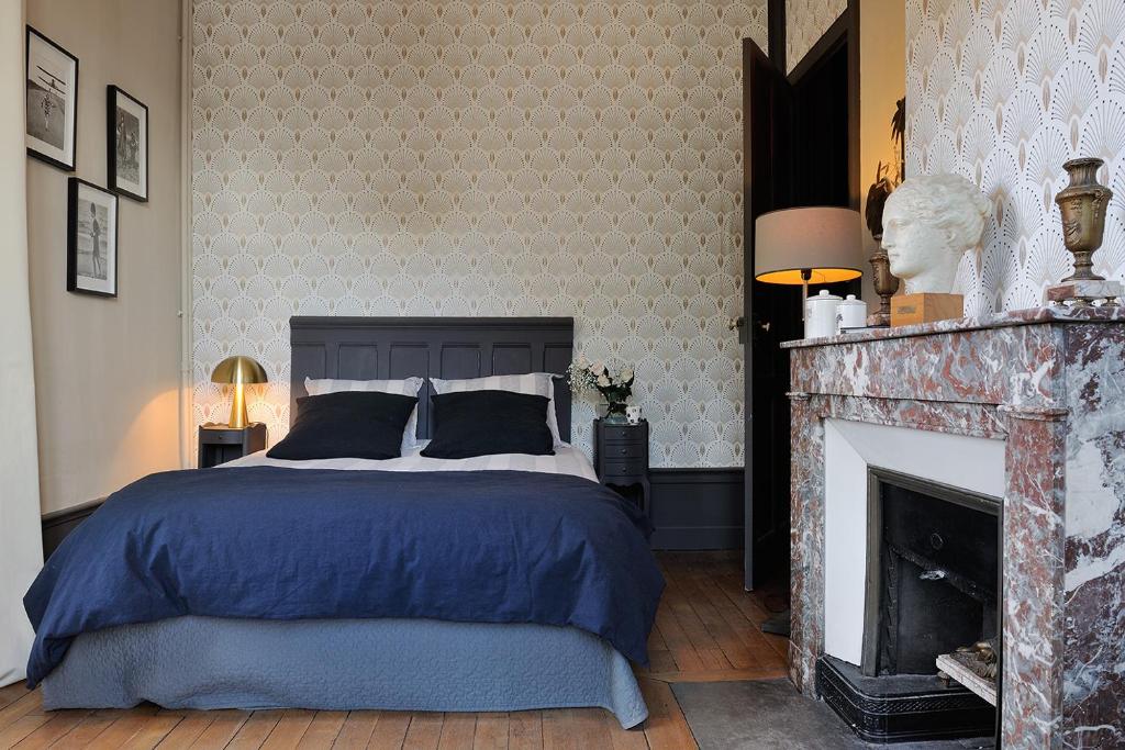 a bedroom with a bed and a fireplace at Manoir de Collonges au mont d'or in Collonges-au-Mont-dʼOr