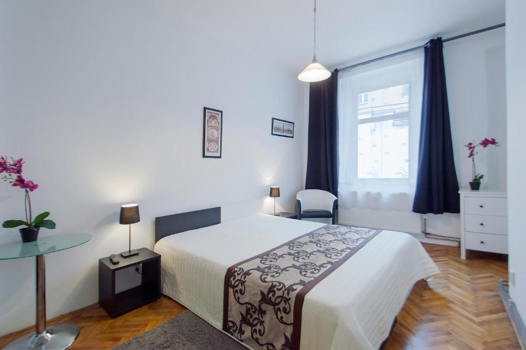 sypialnia z łóżkiem, stołem i oknem w obiekcie Modern Apartment Skolska 20 w Pradze