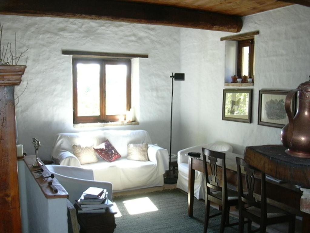 een woonkamer met een witte bank en een tafel bij Della Genga Resort in Arezzola