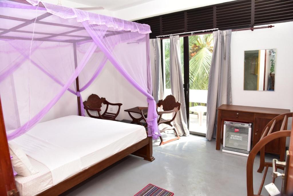 Rúm í herbergi á Relax Inn Hikkaduwa