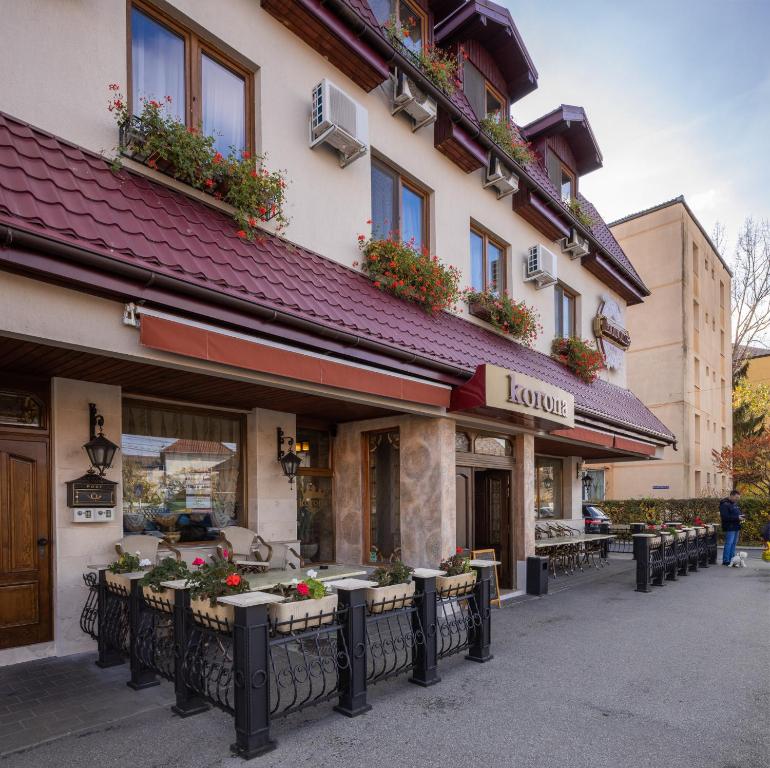 a building with tables and flowers in front of it at Pension Korona in Sibiu