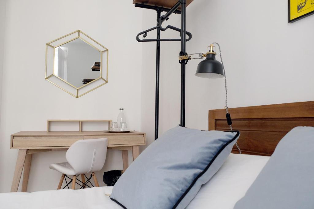 - une chambre avec un lit, un bureau et un miroir dans l'établissement Lisbon Poets Inn, à Lisbonne