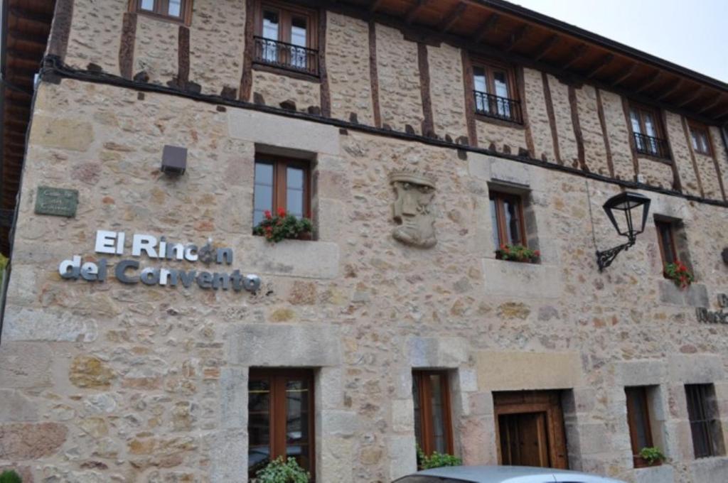 un edificio de piedra con un cartel en el costado en El Rincón Del Convento, en Oña