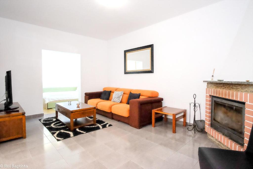 a living room with a couch and a fireplace at Charming House in Monchique with Shared Pool in Monchique