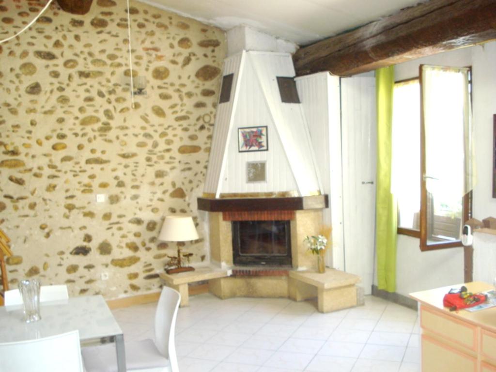 a living room with a stone wall with a fireplace at Maison d&#39;une chambre a Ille sur Tet in Ille-sur-Têt