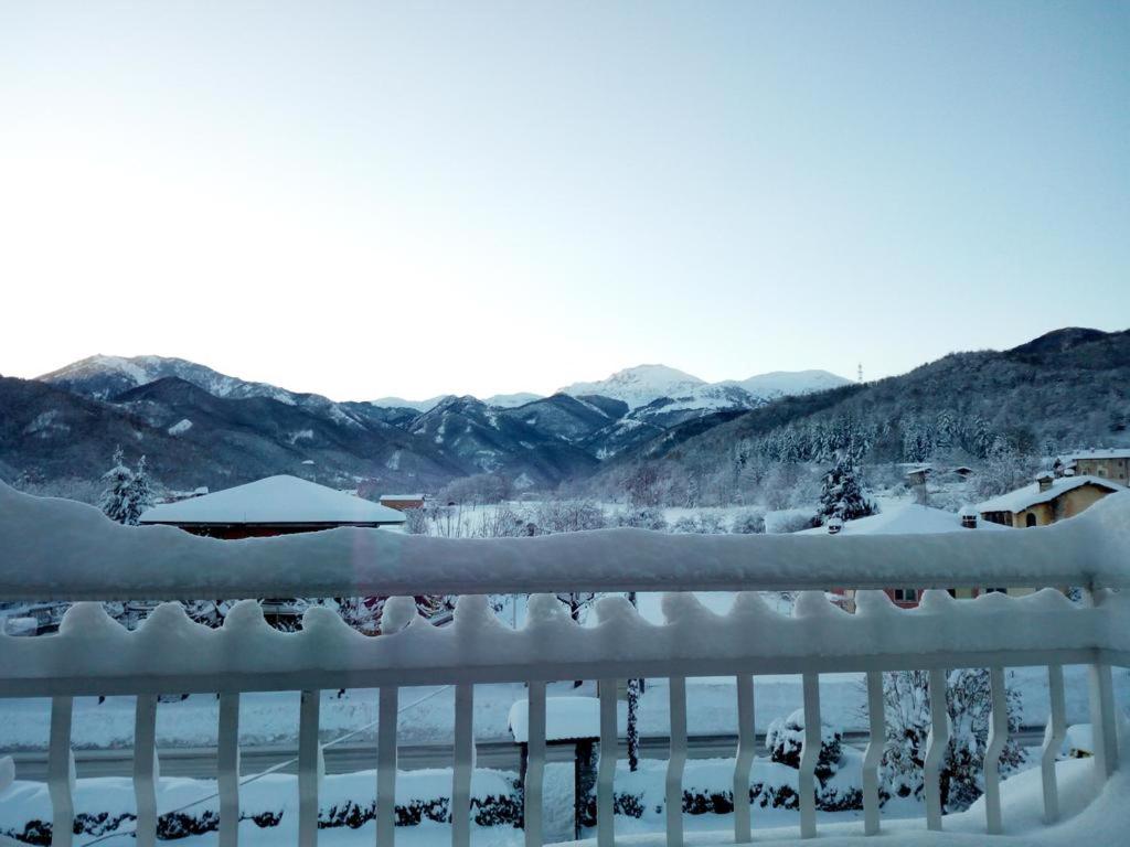 a snow covered balcony with a view of the mountains at casa vacanze morà 2 in Roccaforte Mondovì